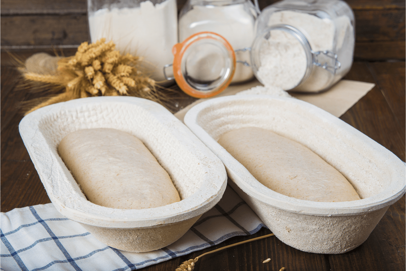 two wood pulp proofing baskets with dough in them