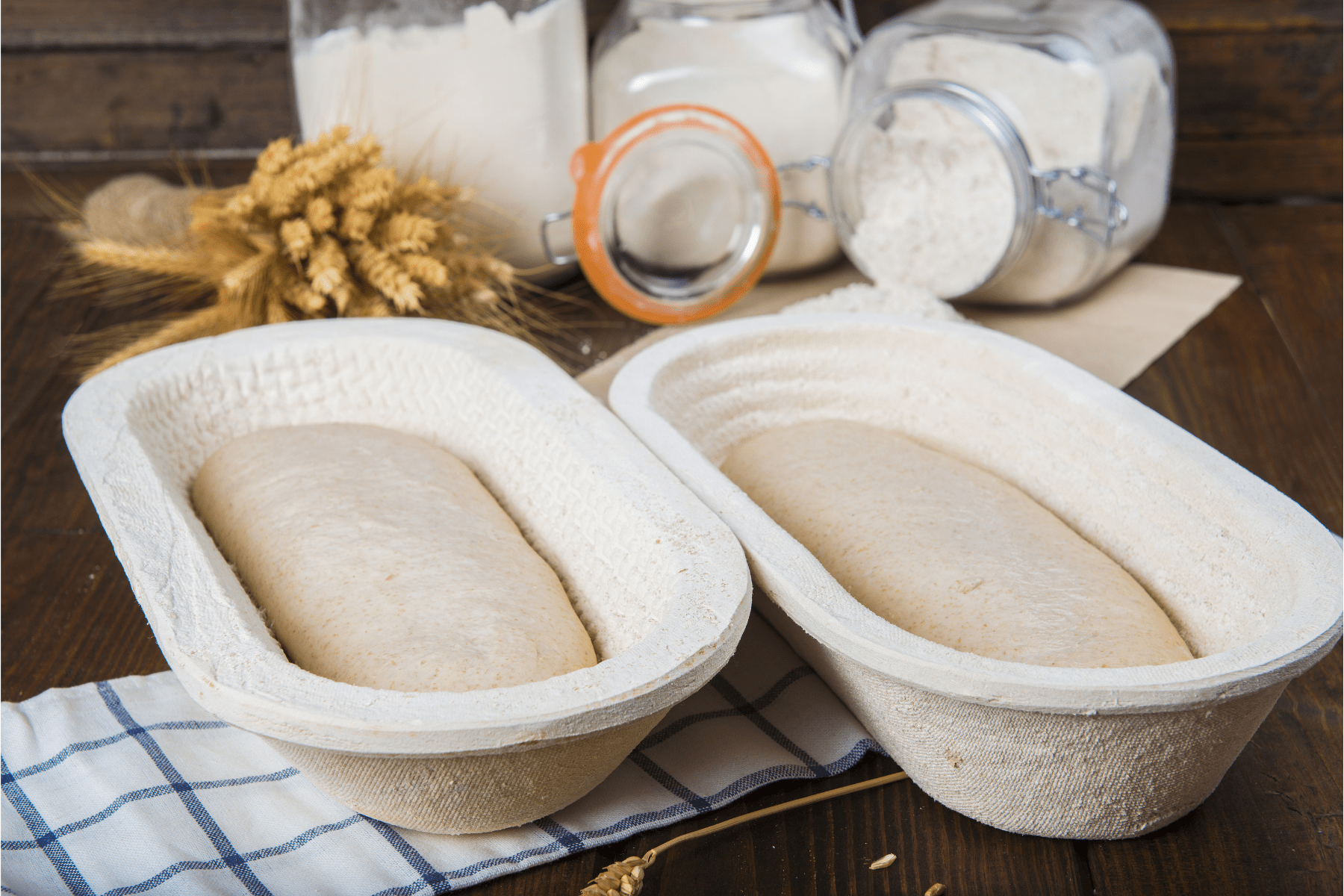 two wood pulp proofing baskets with dough in them